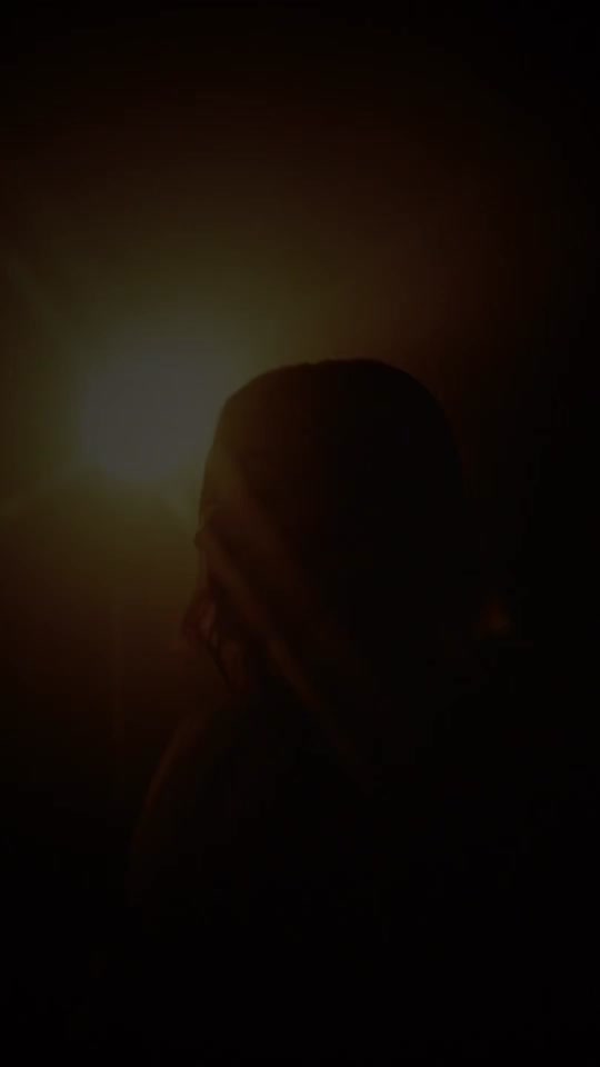 A silhouetted woman in warm sunlight